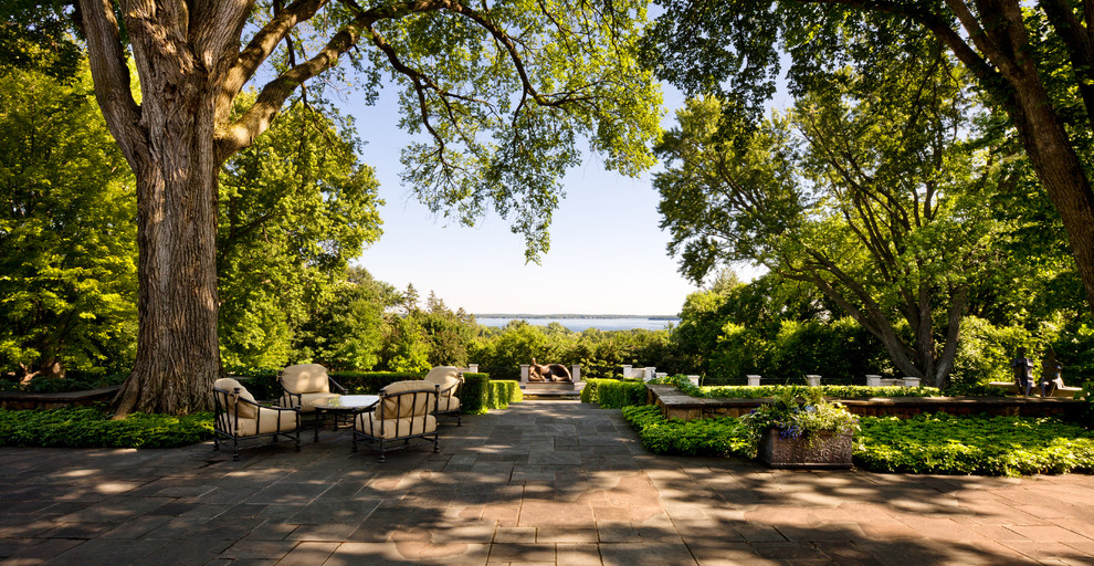 Photo of a huge traditional backyard stone landscaping in Minneapolis.