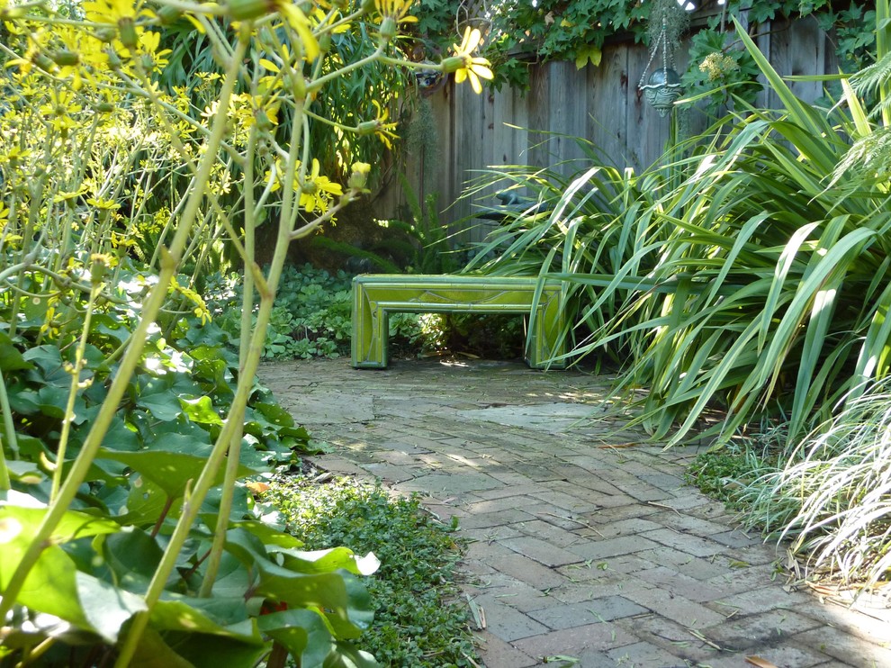 Ispirazione per un giardino eclettico esposto a mezz'ombra di medie dimensioni e in cortile in primavera con un ingresso o sentiero e pavimentazioni in mattoni