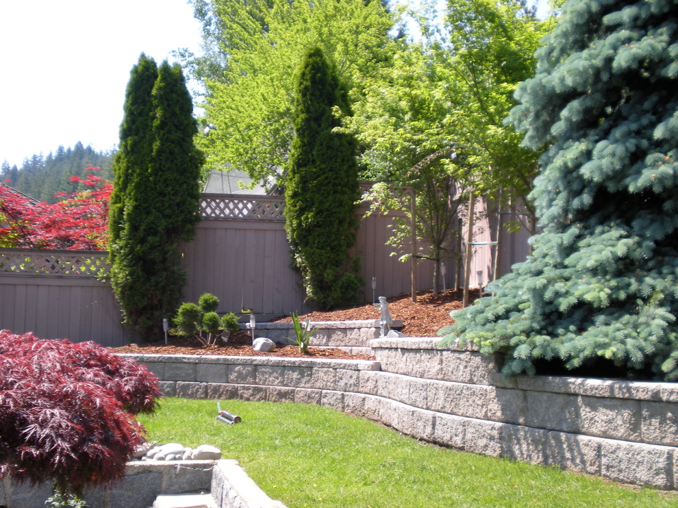 На фото: участок и сад на заднем дворе в стиле ретро с подпорной стенкой с