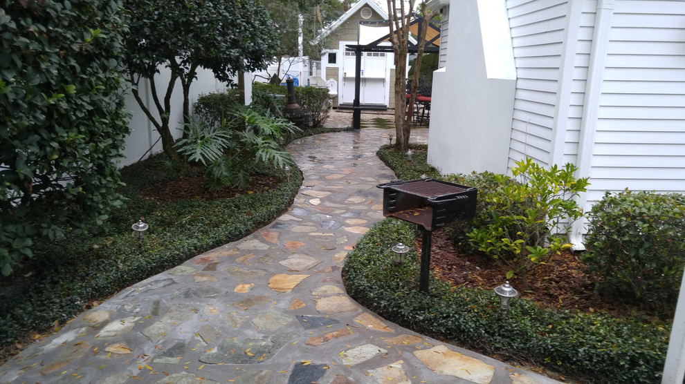 タンパにある中くらいなトラディショナルスタイルのおしゃれな横庭 (天然石敷き、庭への小道、半日向) の写真