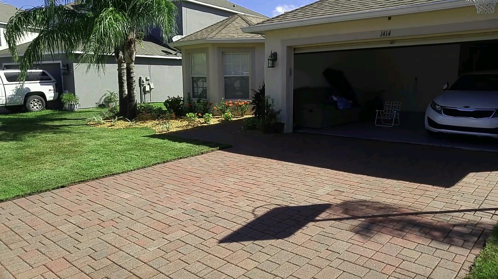 Photo of a medium sized classic front driveway full sun garden in Tampa with brick paving.