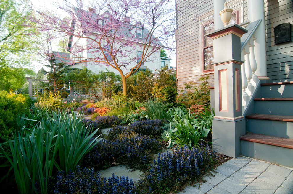На фото: маленький весенний регулярный сад на переднем дворе в классическом стиле с садовой дорожкой или калиткой, полуденной тенью и мощением тротуарной плиткой для на участке и в саду