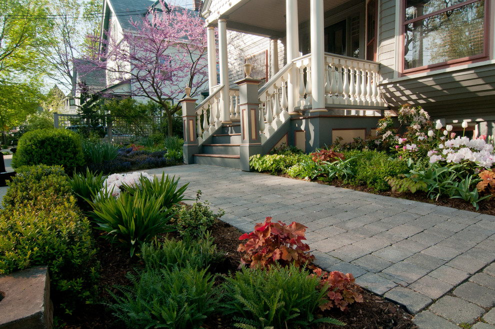 Esempio di un giardino formale classico esposto a mezz'ombra di medie dimensioni e davanti casa in primavera con pavimentazioni in cemento e un ingresso o sentiero
