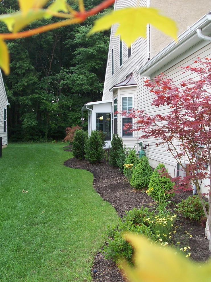 Design ideas for a mid-sized traditional side yard mulch driveway in New York.