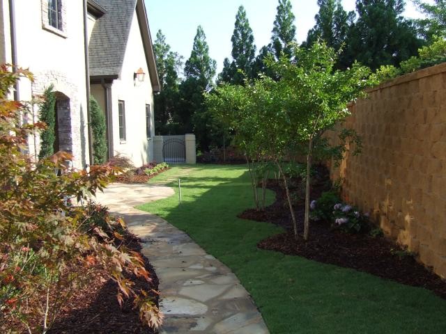 Aménagement d'un jardin latéral de taille moyenne avec une exposition ombragée et des pavés en pierre naturelle.