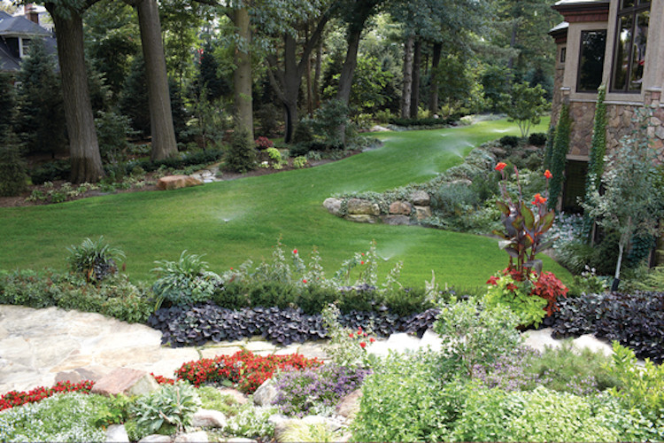 На фото: большой солнечный, весенний регулярный сад на боковом дворе в стиле кантри с садовой дорожкой или калиткой, хорошей освещенностью и покрытием из каменной брусчатки