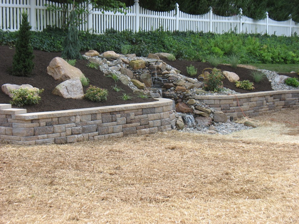 Design ideas for a mid-sized traditional full sun hillside mulch water fountain landscape in Philadelphia for summer.