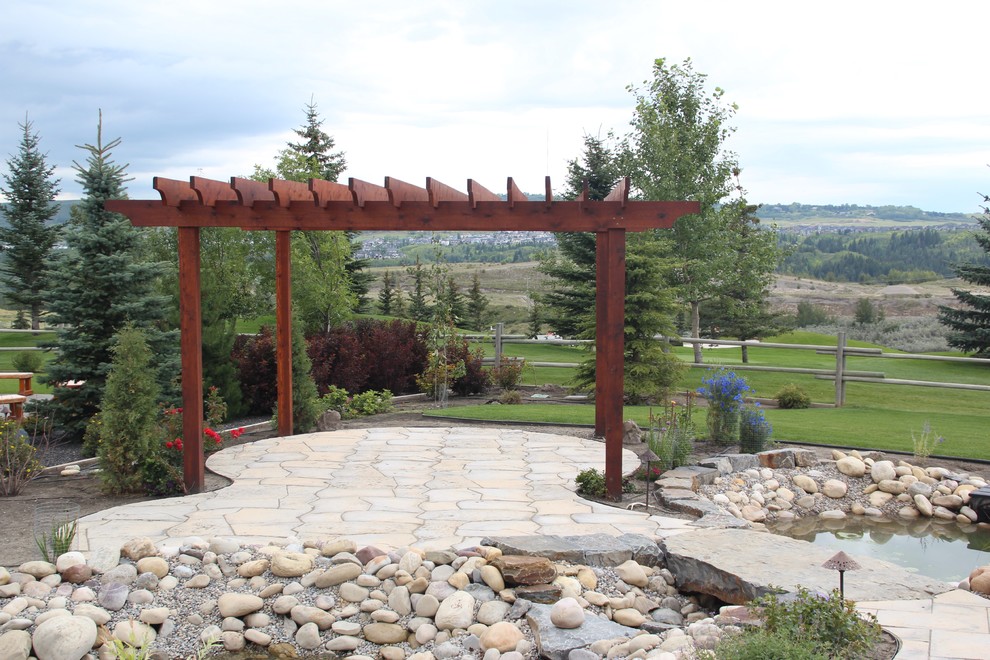 Großer, Halbschattiger Moderner Gartenteich hinter dem Haus mit Natursteinplatten in Calgary