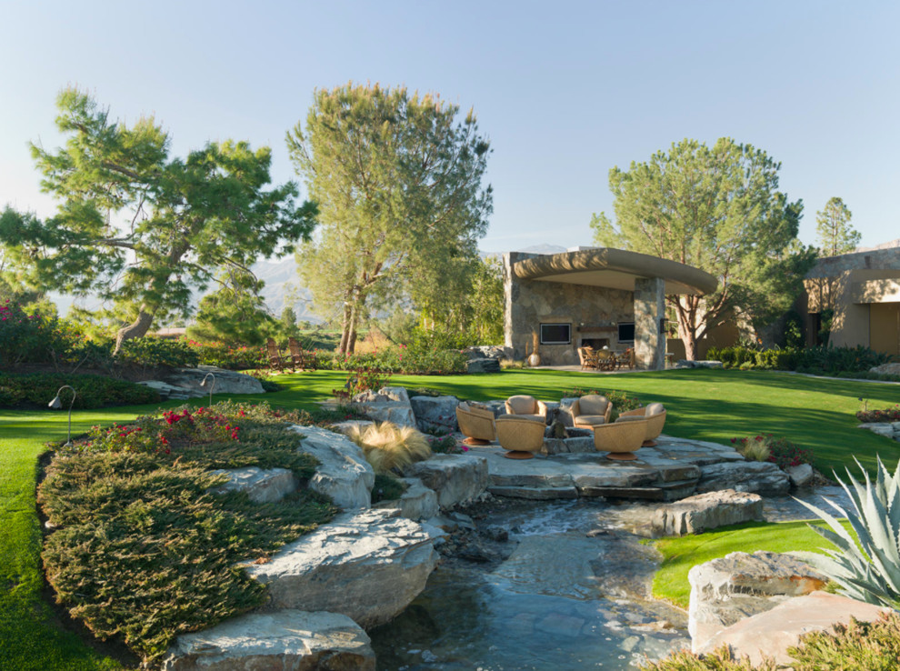 Cette photo montre un jardin chic de taille moyenne et l'été avec un foyer extérieur, une exposition partiellement ombragée et des pavés en pierre naturelle.