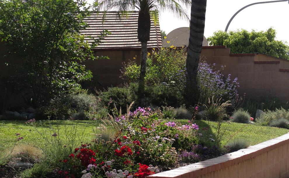 Esempio di un giardino classico esposto in pieno sole di medie dimensioni e davanti casa in primavera con un ingresso o sentiero e ghiaia