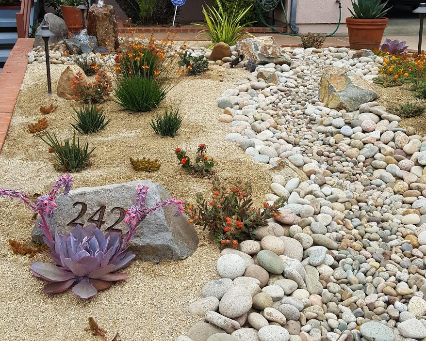 Kleiner Mediterraner Vorgarten im Sommer mit Wasserspiel, direkter Sonneneinstrahlung und Natursteinplatten in San Diego