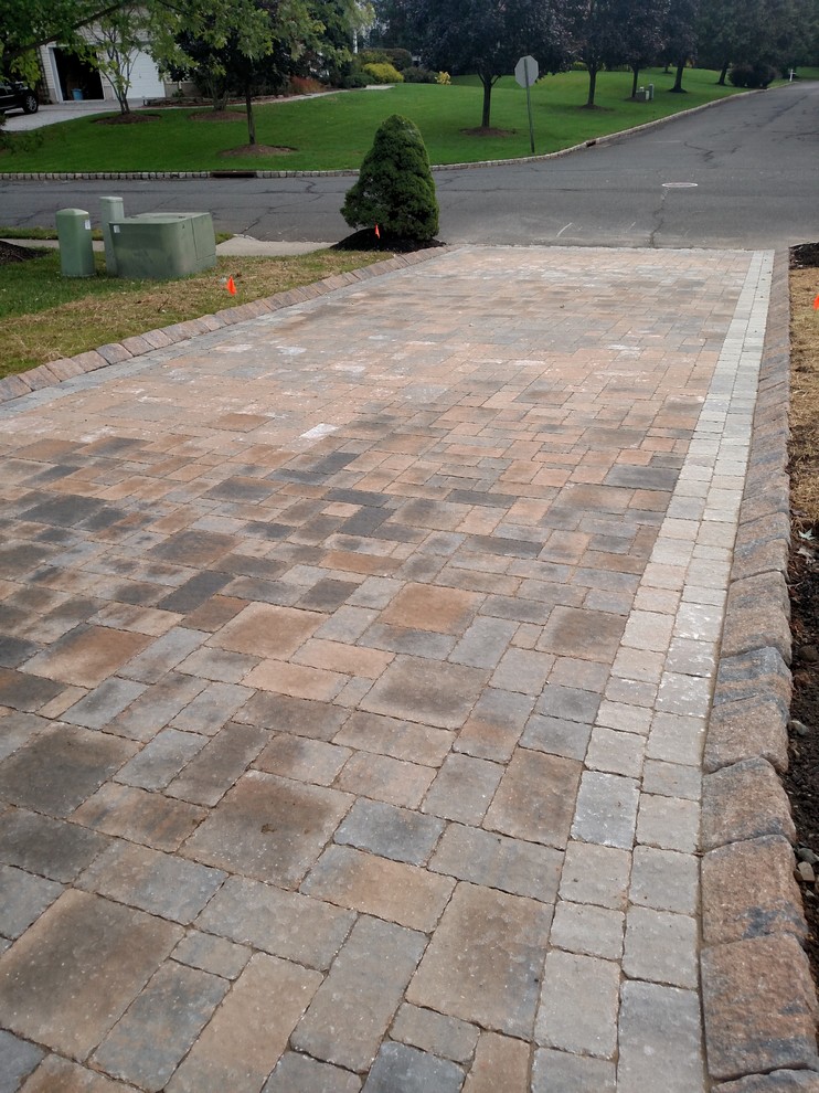 Inspiration for a mid-sized traditional full sun front yard brick driveway in New York.