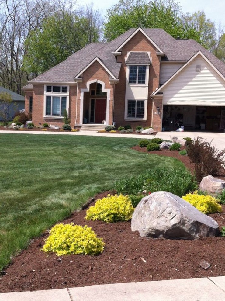 This is an example of a large traditional front yard concrete paver driveway in Other.