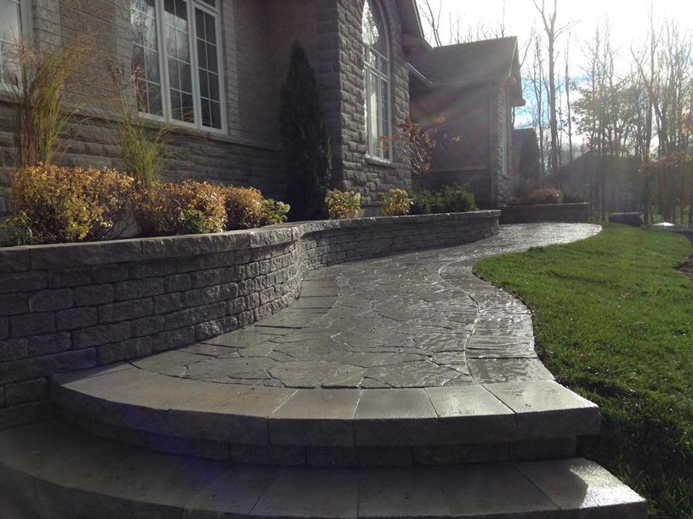 Photo of a medium sized classic front garden in Ottawa with a retaining wall and natural stone paving.
