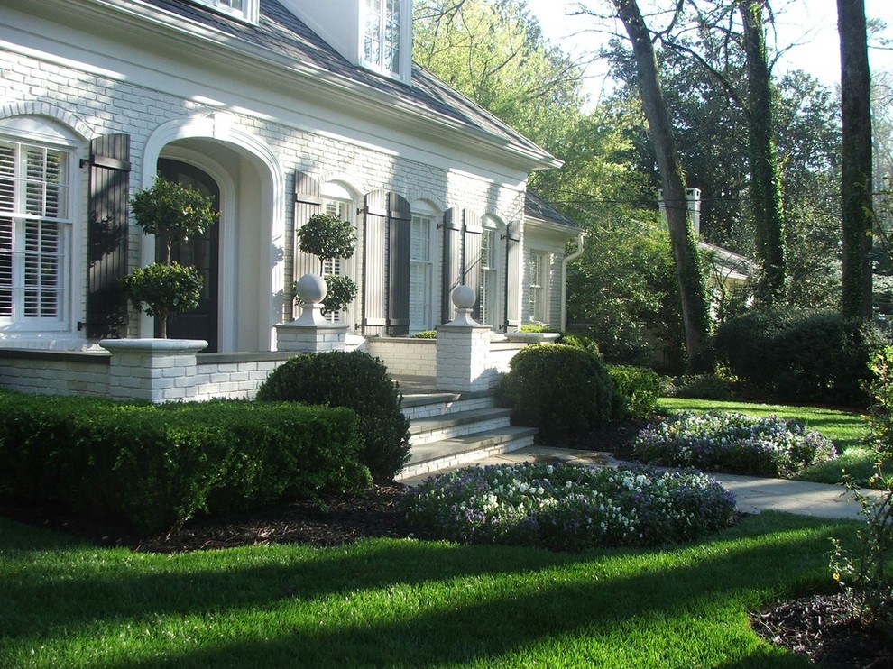 Photo of a large classic front driveway fully shaded garden in Atlanta with natural stone paving.