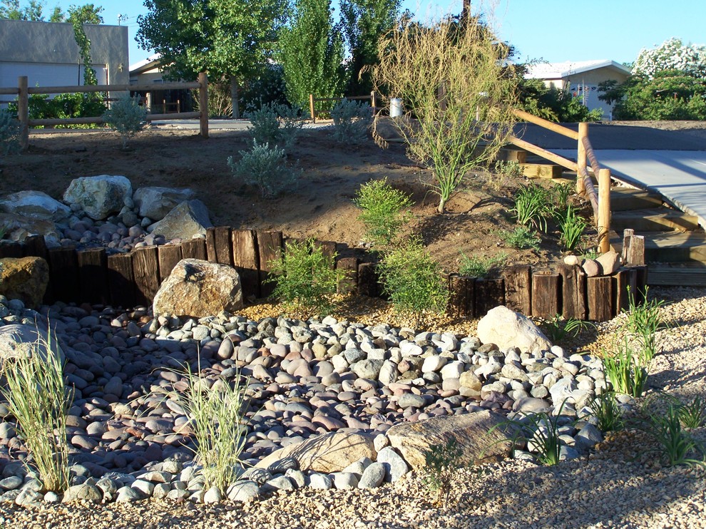 Photo of a mid-sized rustic drought-tolerant and full sun front yard gravel retaining wall landscape in Los Angeles for spring.
