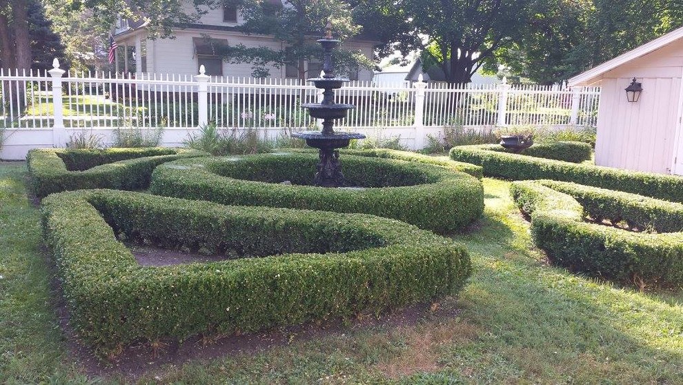 Foto de jardín clásico en patio trasero con jardín francés y fuente