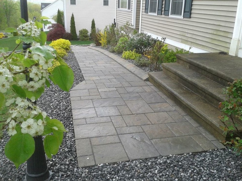 Inspiration for a small transitional front yard concrete paver garden path in New York.