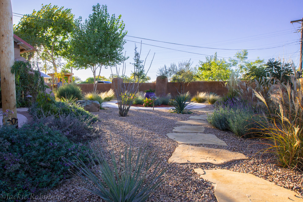 This is an example of a mid-sized mediterranean partial sun backyard concrete paver landscaping in Albuquerque.