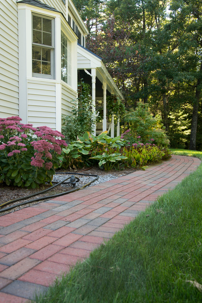 Inspiration for a large traditional front driveway full sun garden in Boston with brick paving.