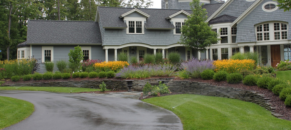 Foto di un giardino classico di medie dimensioni e davanti casa con un muro di contenimento e pavimentazioni in pietra naturale