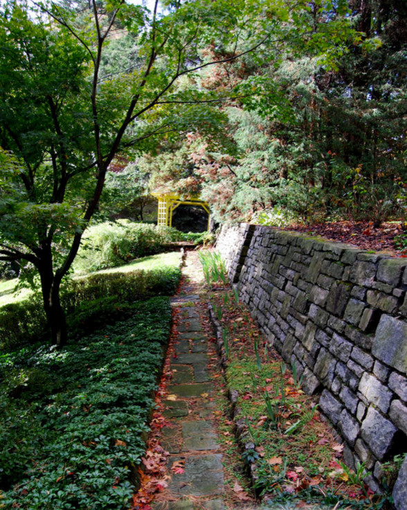 Modelo de jardín de estilo zen grande en verano en ladera con muro de contención y exposición parcial al sol