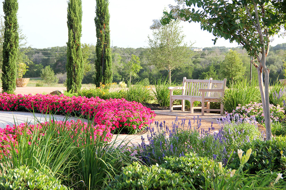 Aménagement d'un grand jardin avant méditerranéen avec une exposition ensoleillée et des pavés en pierre naturelle.