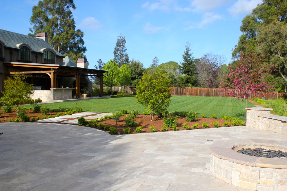 Foto di un ampio giardino minimalista esposto a mezz'ombra dietro casa con un focolare e pavimentazioni in pietra naturale