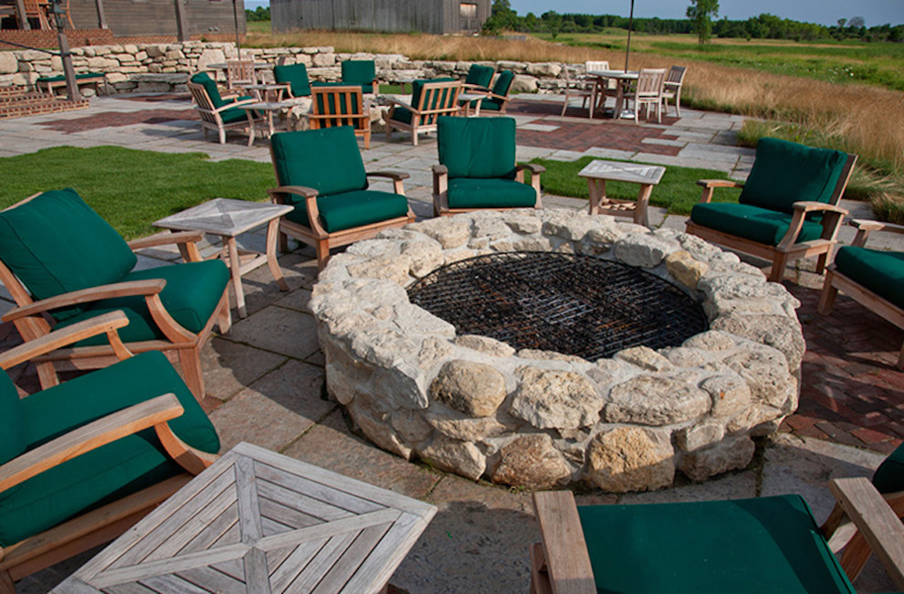 Maritimer Garten hinter dem Haus mit Feuerstelle und Natursteinplatten in Milwaukee