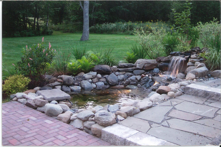 This is an example of a traditional partial sun backyard stone landscaping in Other.