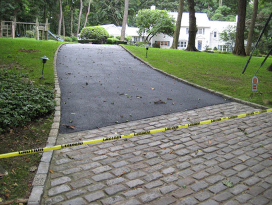 Design ideas for a large traditional front driveway partial sun garden in New York with brick paving.