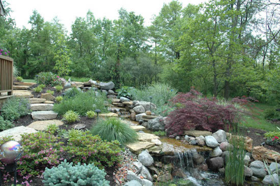 Idee per un giardino classico di medie dimensioni e dietro casa con fontane e pavimentazioni in pietra naturale