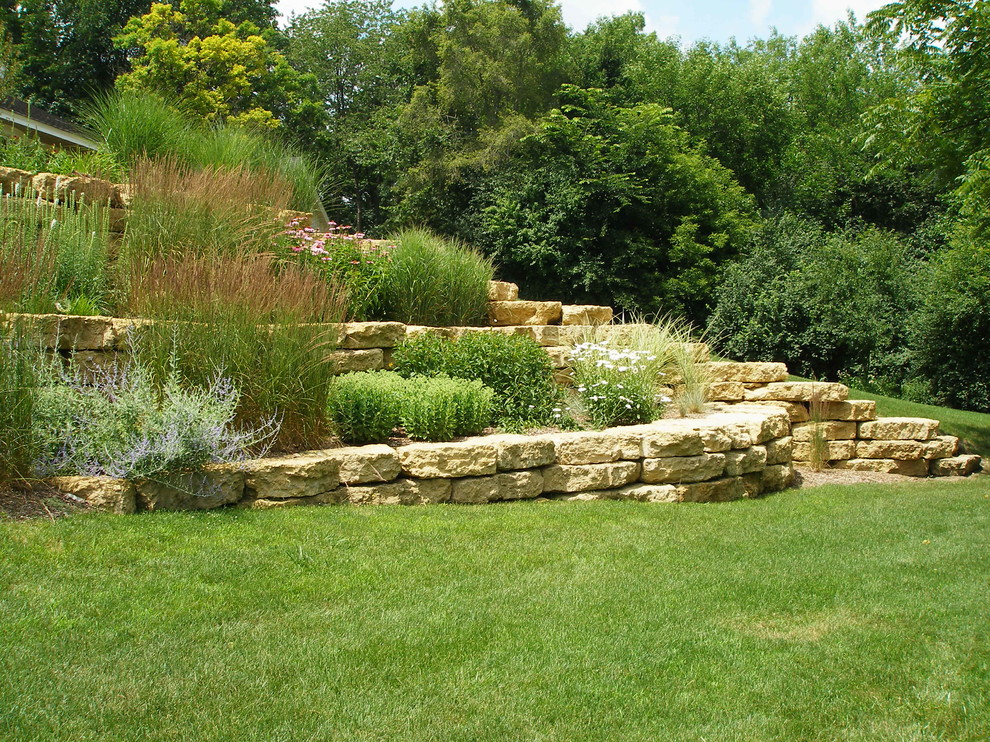 Idee per un giardino classico di medie dimensioni e nel cortile laterale con un muro di contenimento e pavimentazioni in pietra naturale