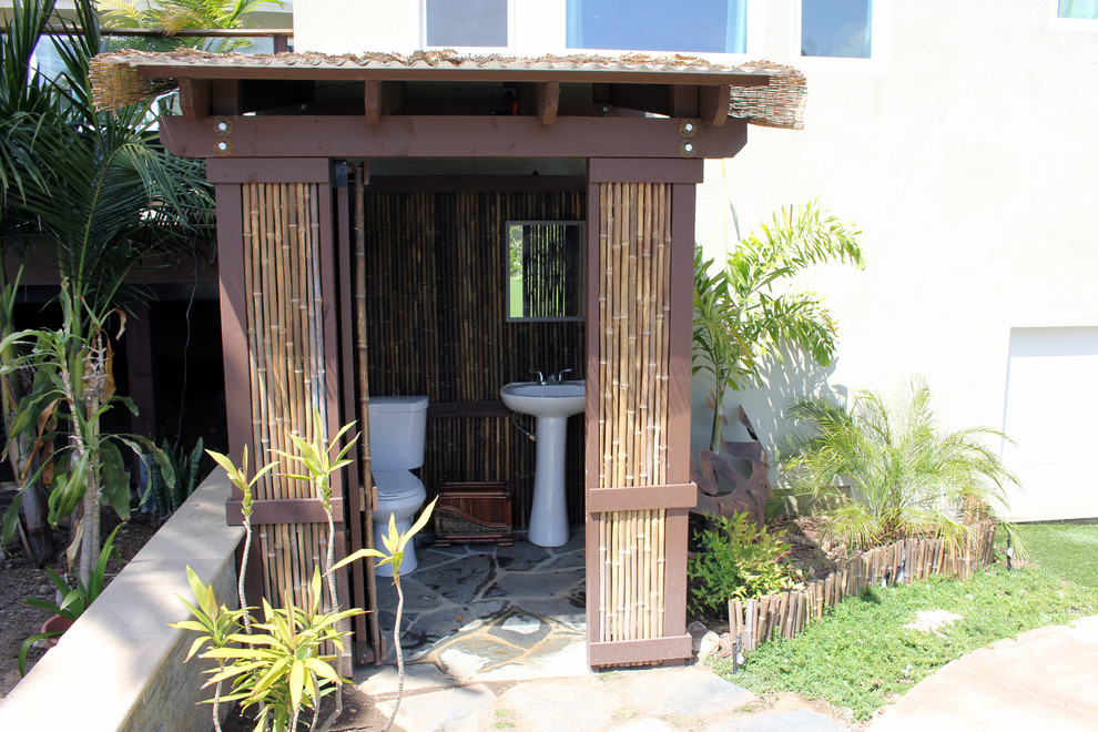 Ispirazione per un piccolo giardino tropicale esposto a mezz'ombra dietro casa con pavimentazioni in pietra naturale