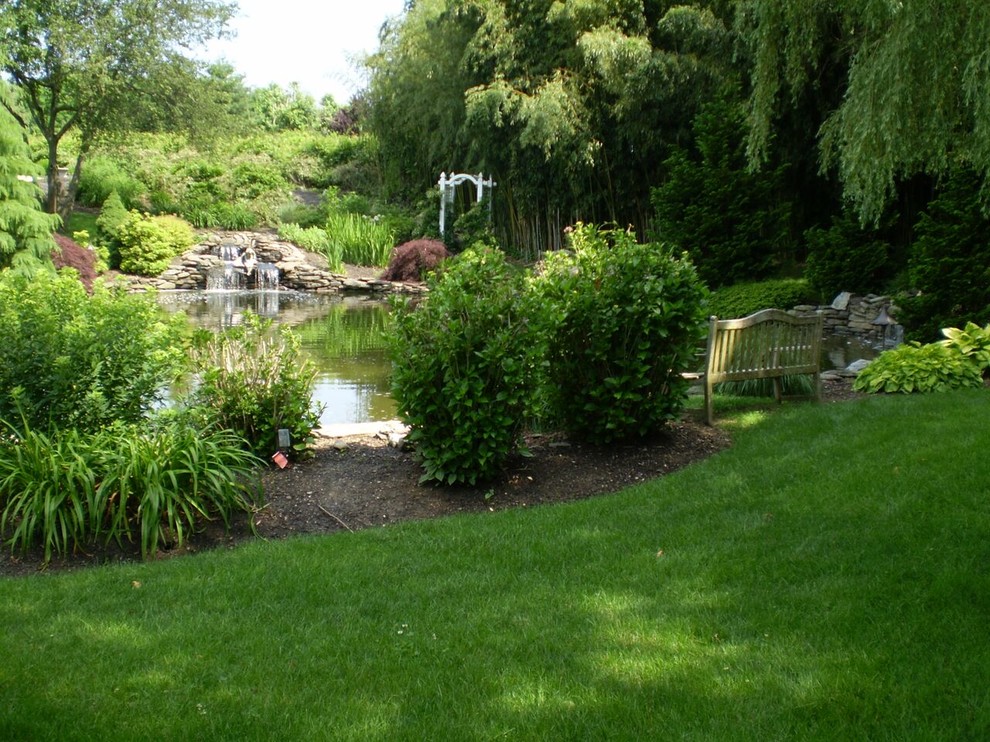 Foto de jardín clásico de tamaño medio en patio trasero con jardín francés, estanque y exposición parcial al sol