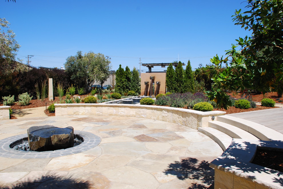 Foto di un grande giardino formale mediterraneo esposto a mezz'ombra dietro casa con fontane e pavimentazioni in cemento