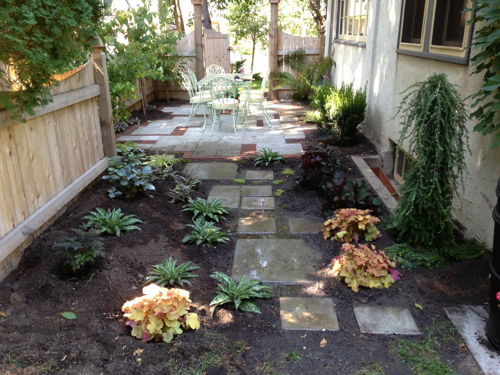 Exemple d'un petit jardin latéral éclectique l'été avec une exposition ombragée et des pavés en béton.