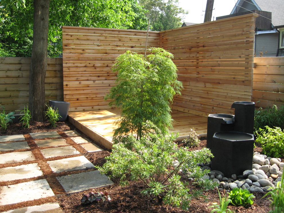 This is an example of a modern garden in Toronto with a water feature and decking.