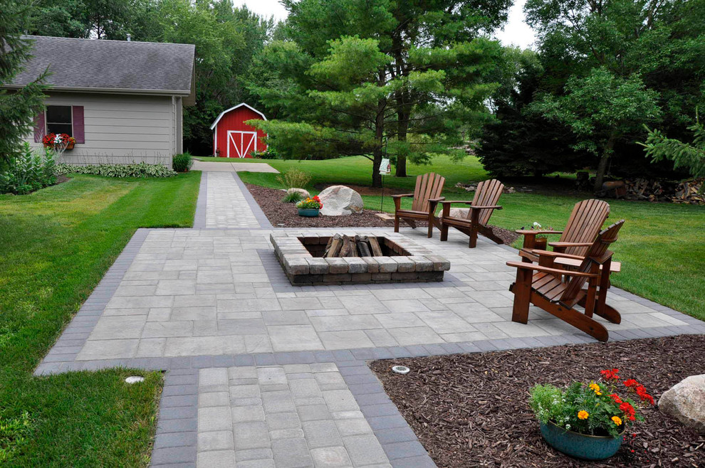 Example of a mid-sized transitional backyard concrete paver patio design in Minneapolis with a fire pit