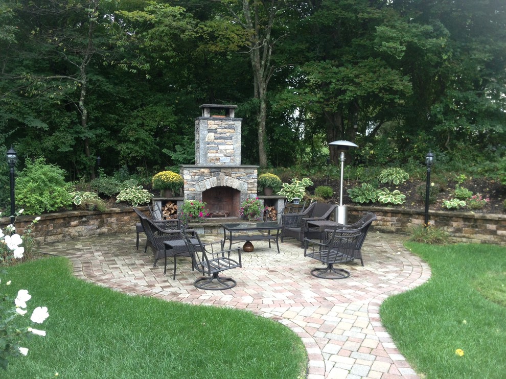 На фото: регулярный сад среднего размера на заднем дворе в классическом стиле с местом для костра, полуденной тенью и покрытием из каменной брусчатки
