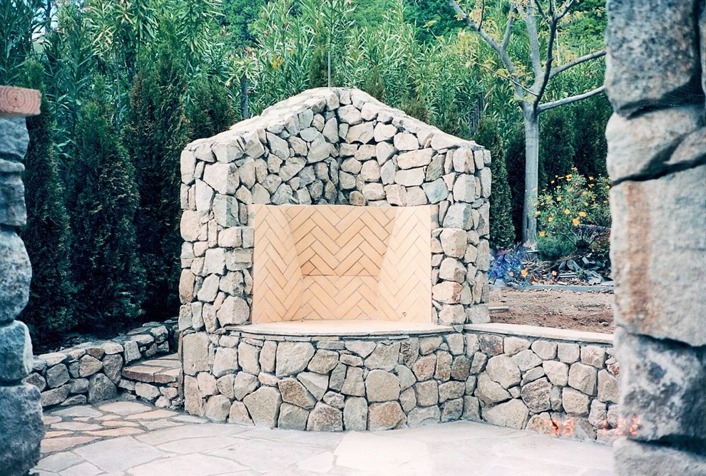 Photo of a small modern back full sun garden for summer in San Francisco with a fire feature and natural stone paving.