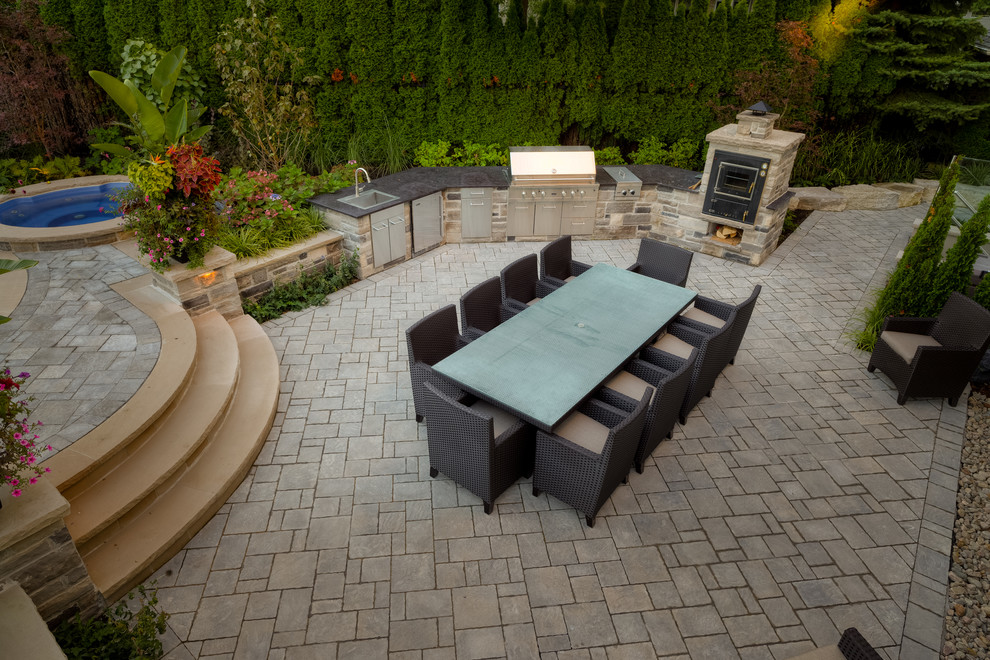 Inspiration for a large transitional backyard concrete paver patio remodel in Toronto with a fire pit