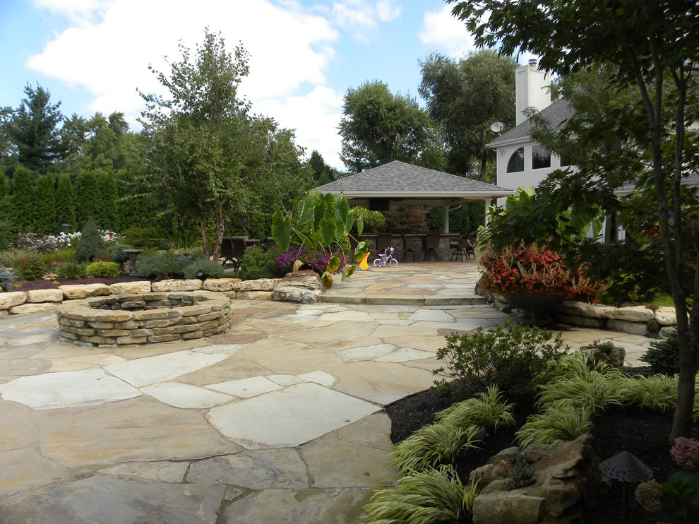 Design ideas for a huge traditional full sun backyard stone landscaping in Chicago with a fire pit for summer.