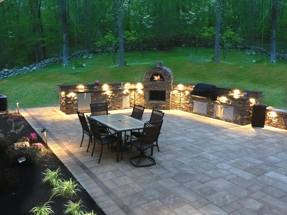 This is an example of a large contemporary back patio in New York with natural stone paving.