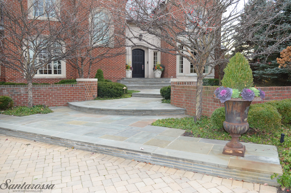 Идея дизайна: участок и сад на переднем дворе в классическом стиле с подпорной стенкой и покрытием из каменной брусчатки