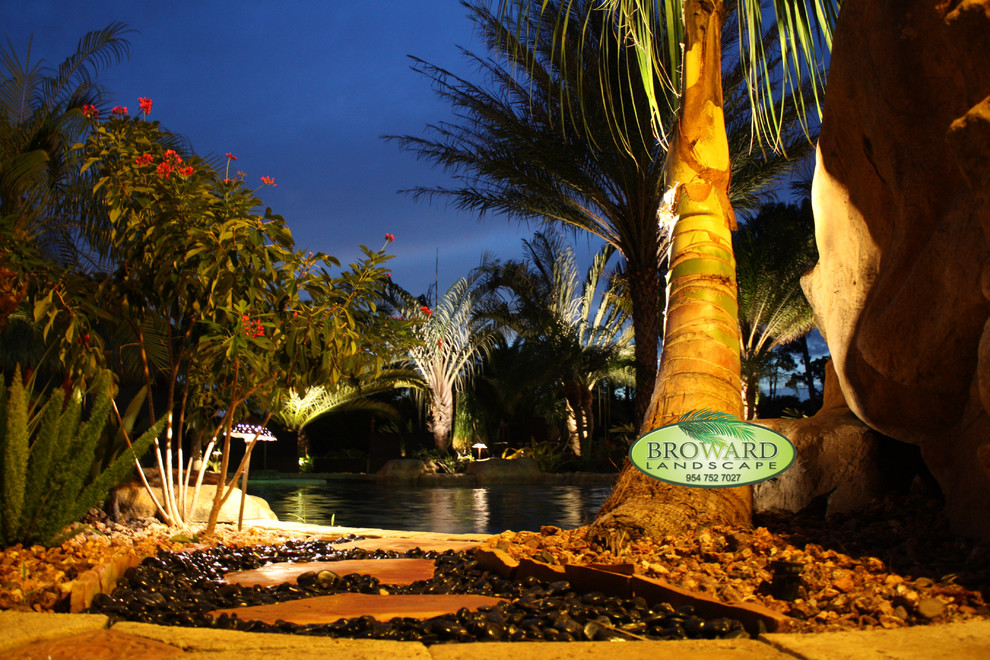 Immagine di un giardino tropicale di medie dimensioni e dietro casa con pavimentazioni in pietra naturale