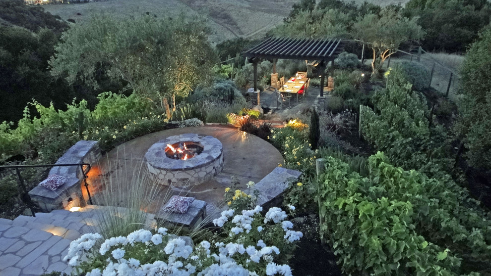 This is an example of a mid-sized traditional full sun backyard brick landscaping in San Francisco with a fire pit for spring.