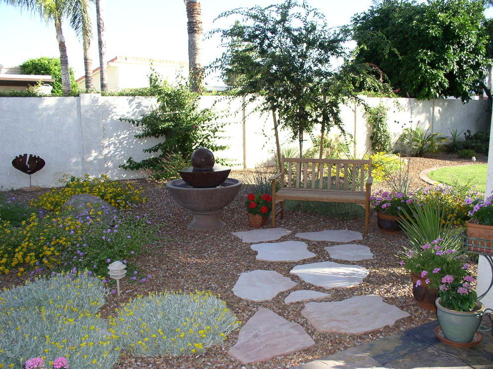This is an example of a mid-sized mediterranean gravel landscaping in Phoenix.