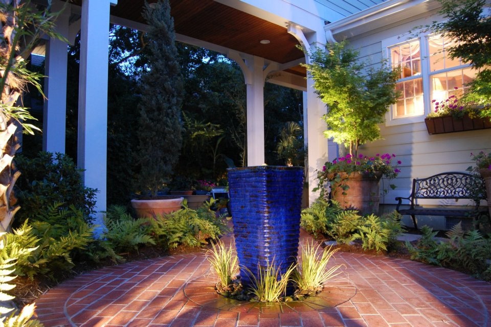Cette image montre un jardin arrière design avec une exposition partiellement ombragée et des pavés en brique.