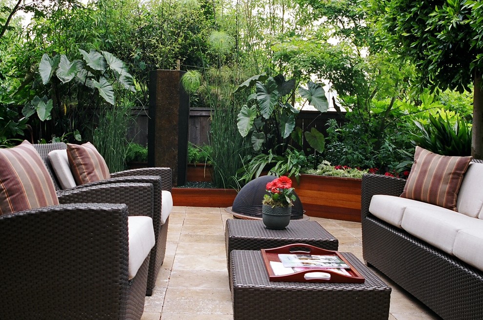 Immagine di un giardino tropicale esposto in pieno sole di medie dimensioni e dietro casa con un giardino in vaso e pavimentazioni in pietra naturale